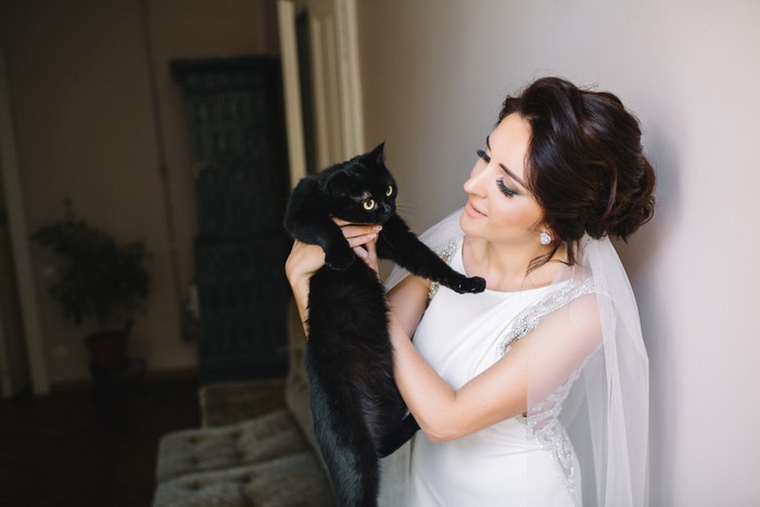 黒猫を抱き上げる花嫁