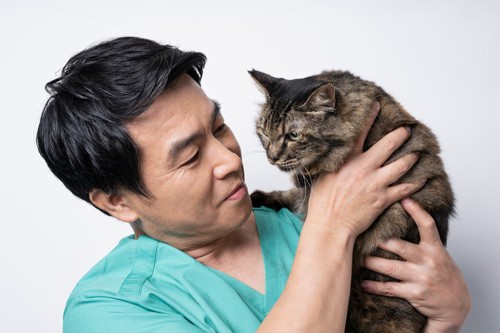 猫を抱っこする医師 