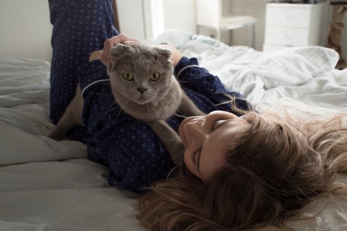 寝ている女性の胸の上にいる猫