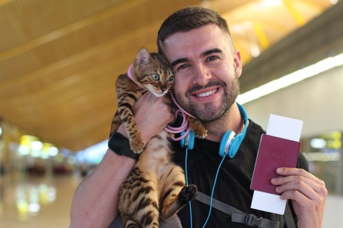 猫を抱っこして旅行する男性