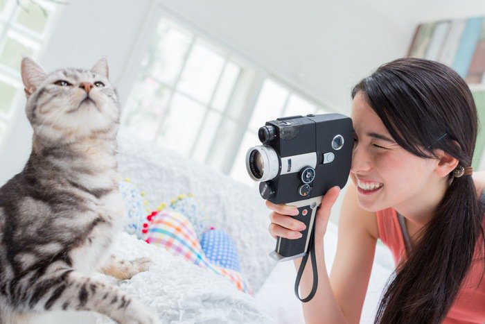 猫を撮影をする女性