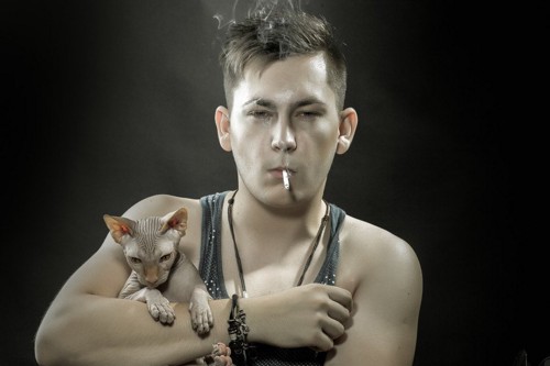 タバコを吸う男子に抱っこされる猫