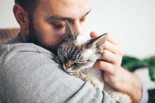 猫を抱き締める男性