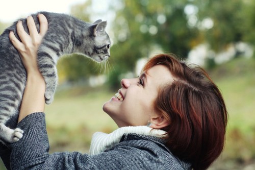 子猫を抱き上げる女性
