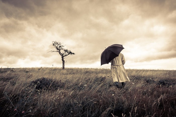 傘をさした人と木のセピア写真