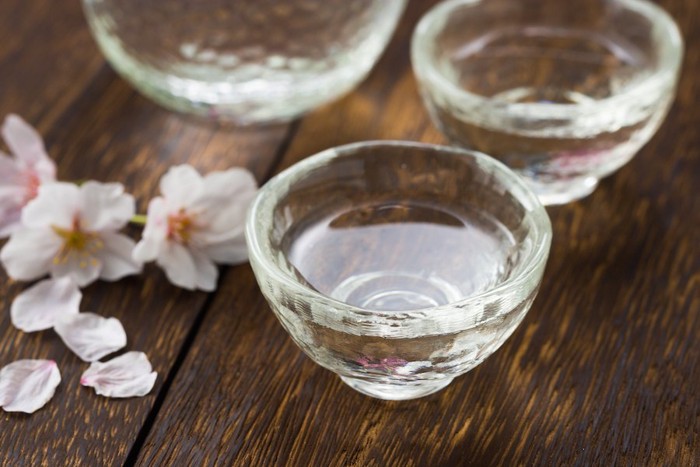 桜の花びらとグラスに入った日本酒