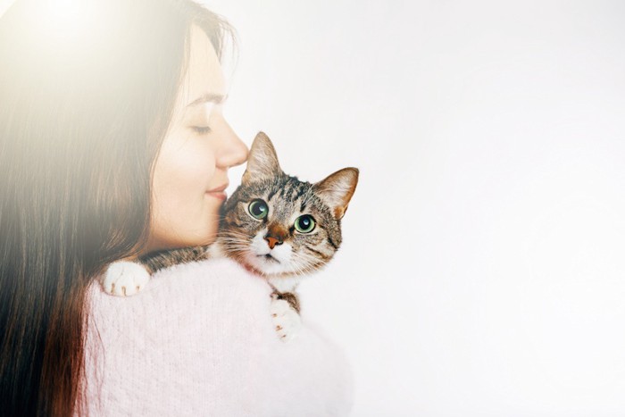 猫を抱っこしてキスをする女性