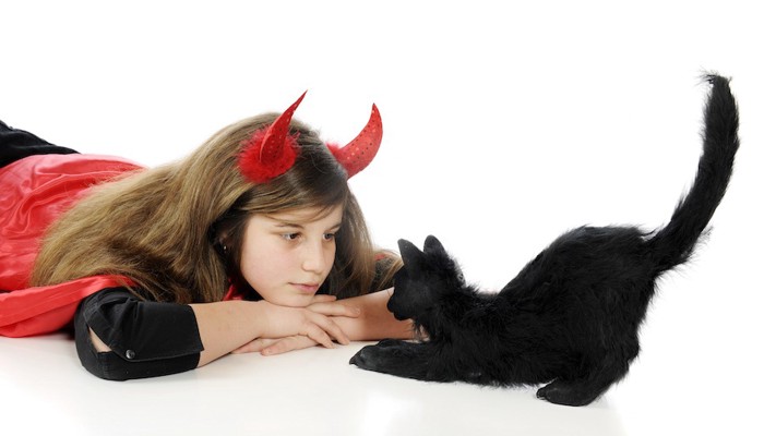 ハロウィンの衣装を着た女の子と黒猫