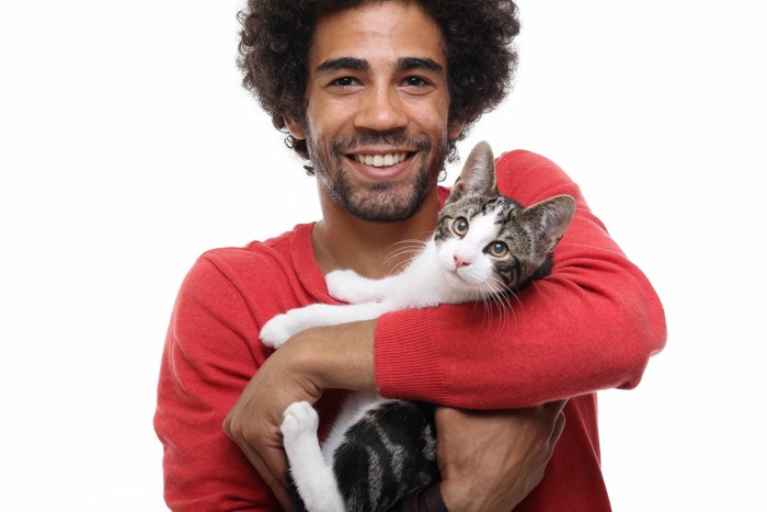男性に抱かれる猫