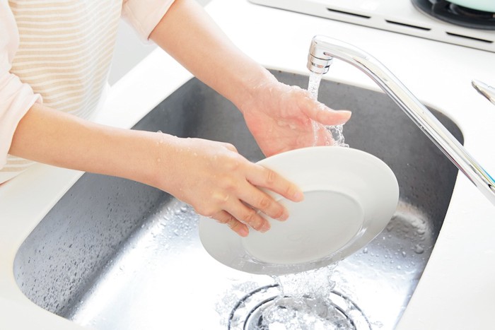 お皿を水洗いする人の手