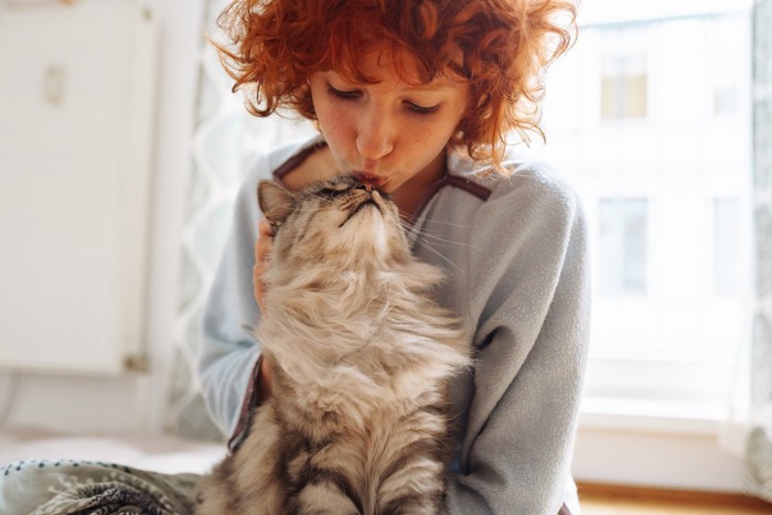 猫にキスをしようとしている女性