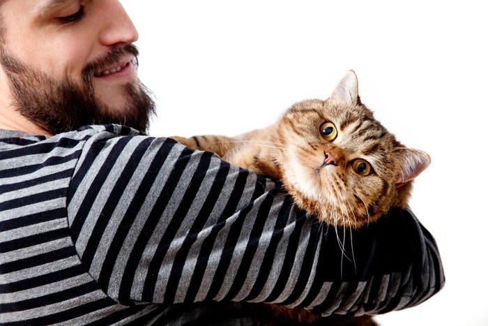 猫を抱く男性の写真