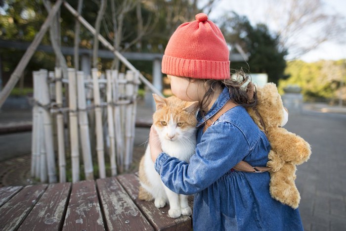 猫をそっと抱きしめる女の子