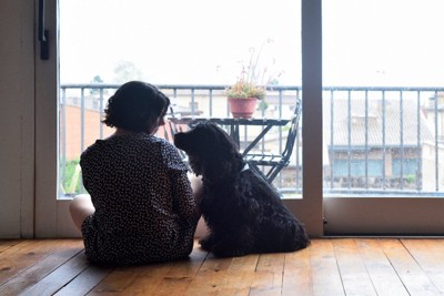 窓際で犬と座っている女性