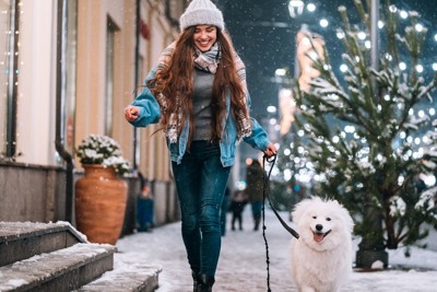 女性と歩く犬