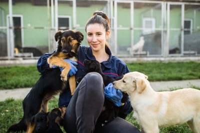 保護施設のスタッフ女性と犬たち