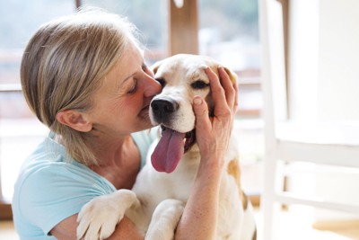 犬にキスする年配の女性