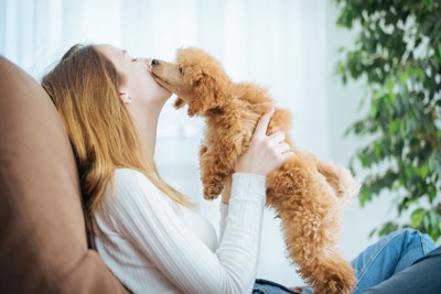 女性の顔にキスする犬