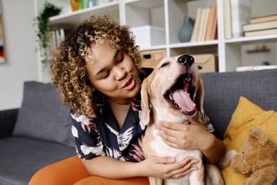 あくびをしている犬と女性