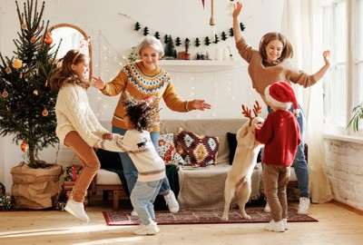 クリスマスパーティーを楽しむ家族と犬