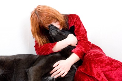 黒い犬を抱きしめている女性