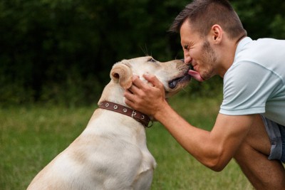 男性の顔を舐める犬