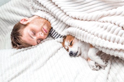 犬といっしょに眠る男性