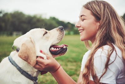 笑顔で見つめ合う女性と犬