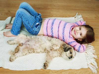 寝転がる子供と犬