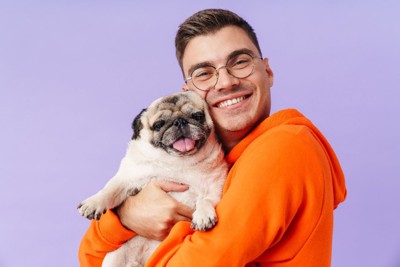 犬を抱っこする男性と笑顔の犬