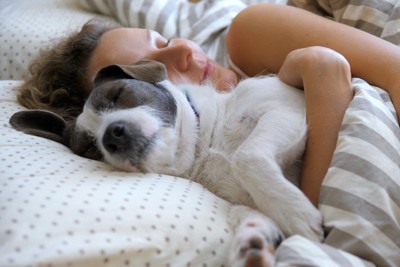 一緒に寝ている女性と犬