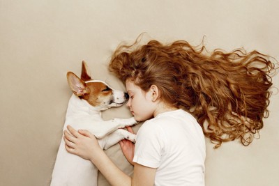一緒に寝ている少女と犬
