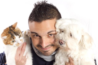 猫と犬を抱いている男性