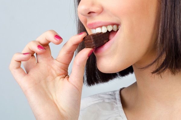 チョコクッキーを食べている女性の口