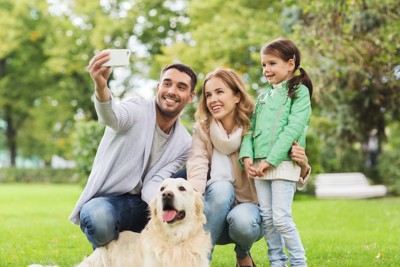 家族写真を撮る人と犬