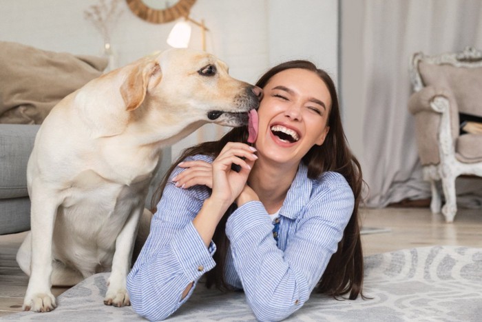 笑顔の女性と舐める犬