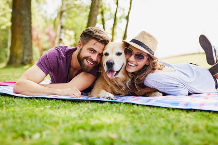 ピクニックを楽しむ男女と犬