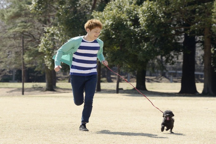 楽しそうに走る男の子と犬