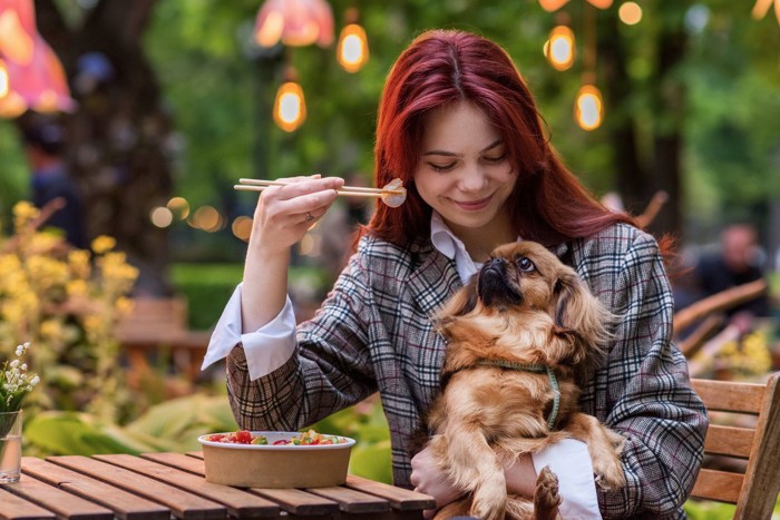 食事をしている女性と犬