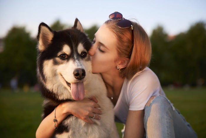 犬を抱き寄せてキスする女性