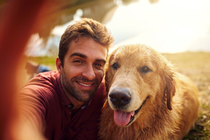 自撮り撮影する男性と犬