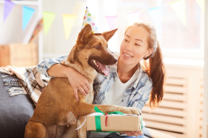 犬の誕生日を祝う女性