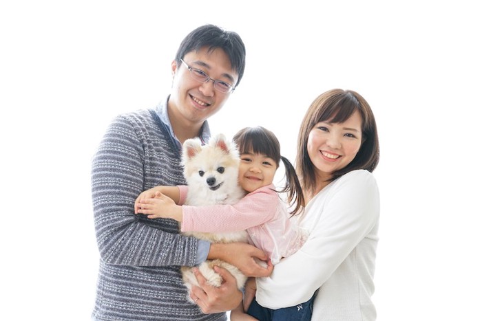 犬を抱いて笑顔の家族