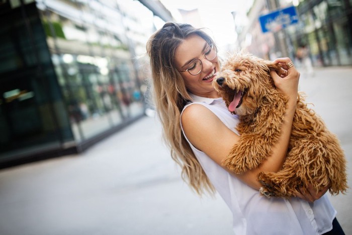 街中で犬を抱く女性