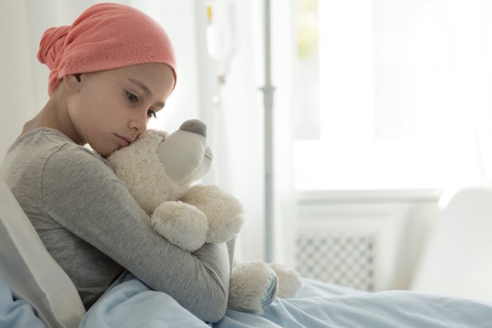 ぬいぐるみを抱いているガン病棟の女の子