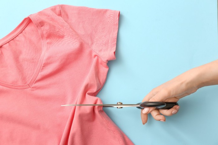 ピンクのTシャツを切るハサミ