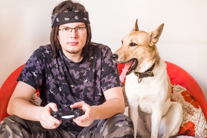 TVゲームをする男性と犬