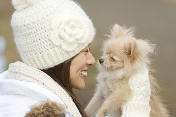 白いニット帽をかぶった女性と犬