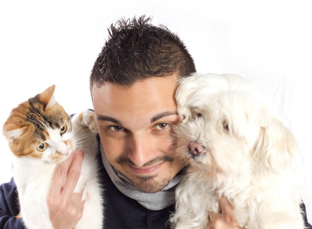 猫と犬を抱いた男性
