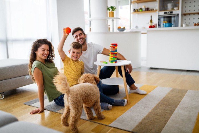 犬と遊ぶ子供と両親